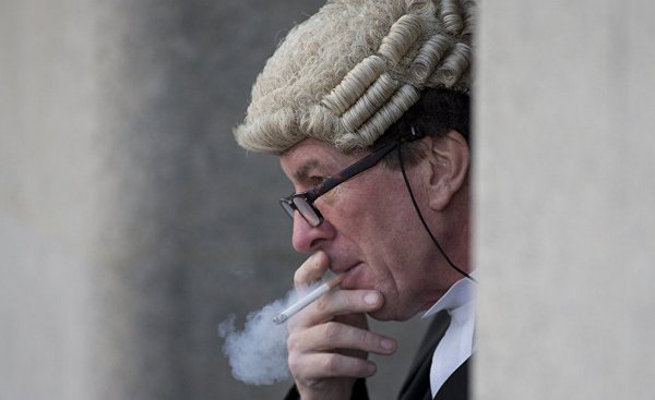 барристер курит у здания Центрального криминального суда в Лондоне