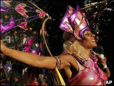 участница карнавала в Ноттинг-Хилле танцует не на платформе, а попросту на тротуаре