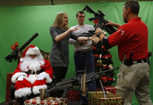 семейная пара стоит с вооружением перед Санта-Клаусом